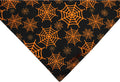 Halloween reversible dog bandana showing pumpkin and spider web patterns in black and orange colours