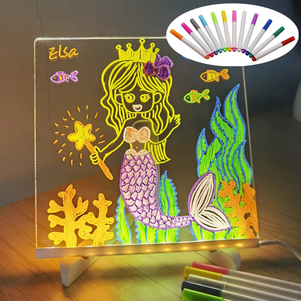 DIY acrylic message board LED night light on desk with colourful writing, USB cable, and pens