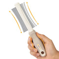 White double-sided dog and cat grooming brush with curved comb and deshedding brush sides.