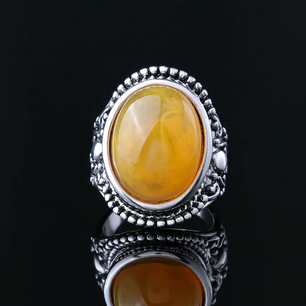 Geometric retro ring in antique silver amber colour on a grey background.