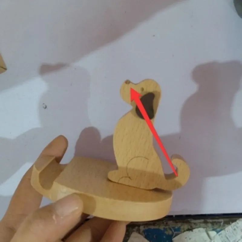 Solid beech wood phone holder with resin puppy decoration and a pound coin in the integrated slot.