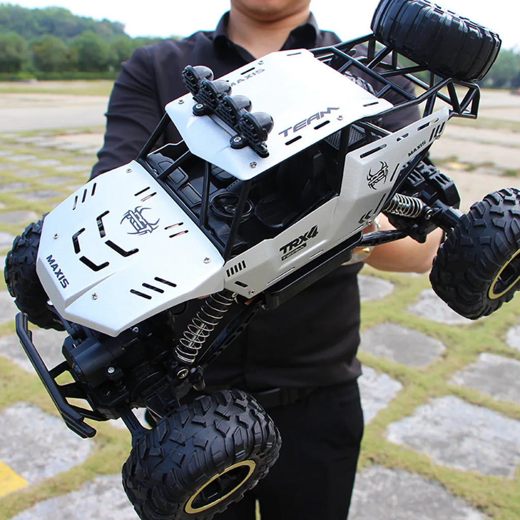 Large black 4WD off-road remote control car with 2.4G wireless controller on rough terrain
