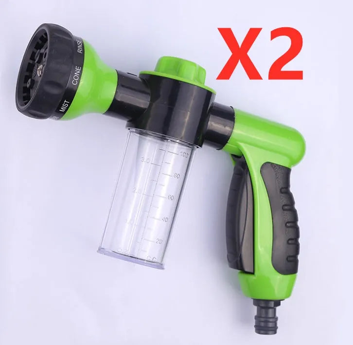 Green high-pressure foam spray gun with adjustable nozzle and attached water hose for car and garden cleaning.