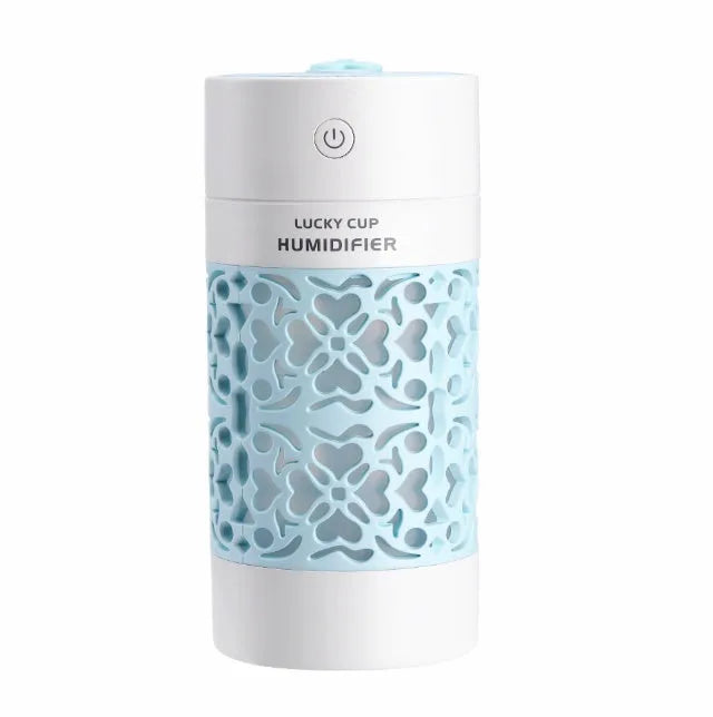 Lucky desktop humidifier 250ml USB powered in black with blue water bottle showing mist output on office desk