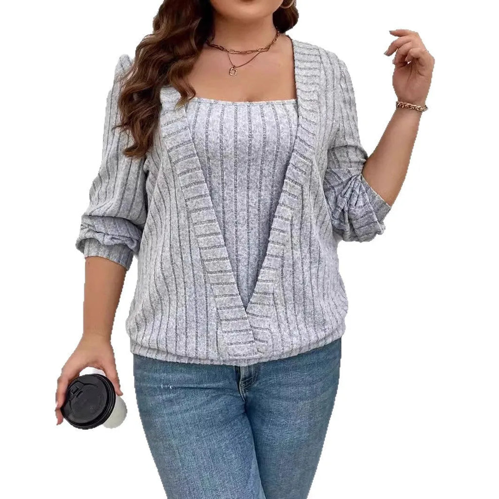 Solid colour rib fabric V-neck long sleeve top with a false two-piece suit design on a hanger.