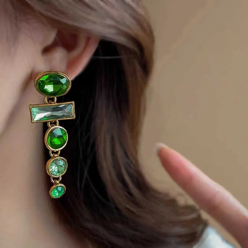 Retro green gradient geometric stud earrings with long silver tassel drop on a white background.
