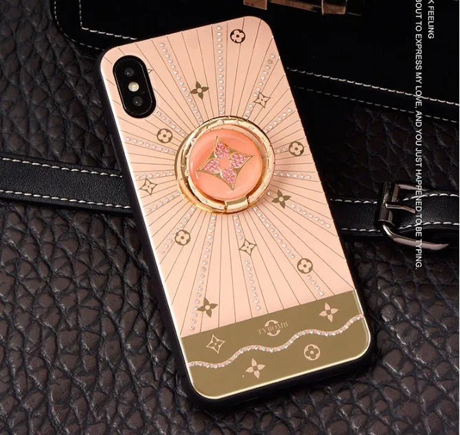 Gold colour metal diamond ring stand attached to the back of an iPhone.