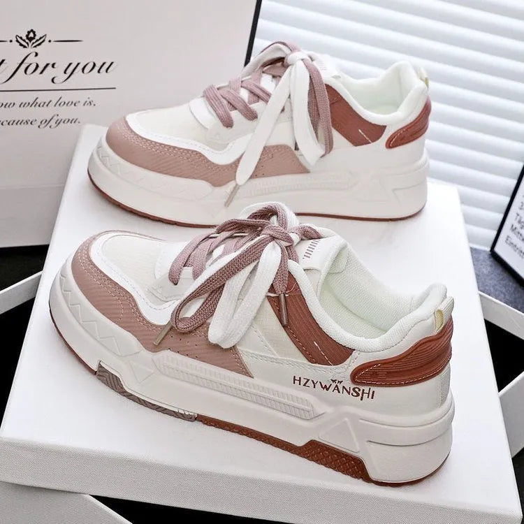 Beige children's lace-up trainers with cross straps over foot and thick rubber platform sole.