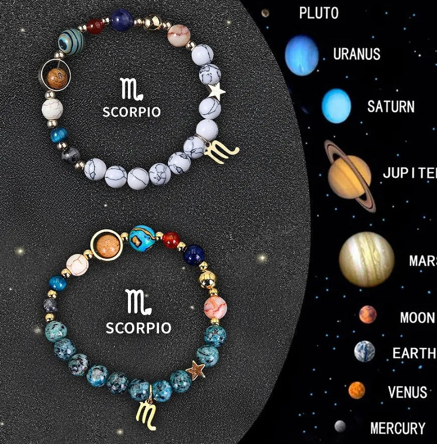 Set of twelve natural stone bead bracelets on a table, each with different coloured beads representing zodiac signs, showing adjustable cotton cord.