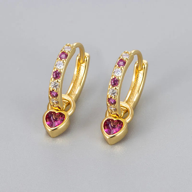 Women's heart-shaped earclip earrings with a coloured zircon or stone centre, in gold or white gold colour.