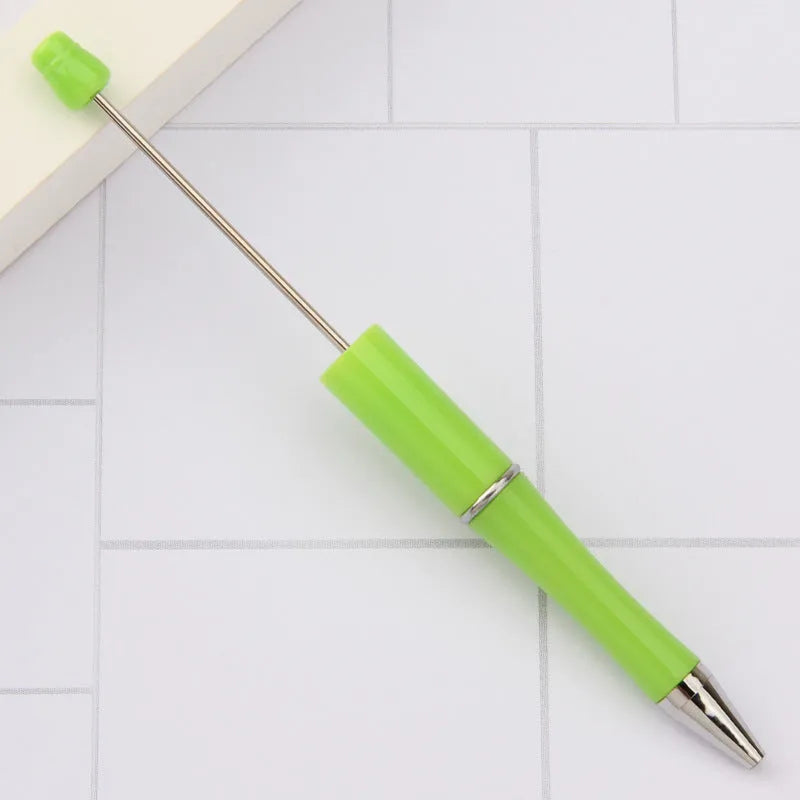 Colourful spinning ballpoint pen with plastic beads on a white background.