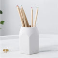 Round silicone pen holder 80x95mm in white on a desk holding pens and pencils