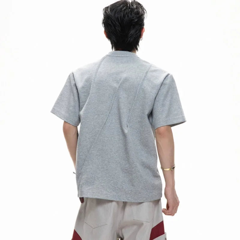 Men's loose-fit grey cotton T-shirt with pleated asymmetric stitching detail on the front, round neck, short sleeves.