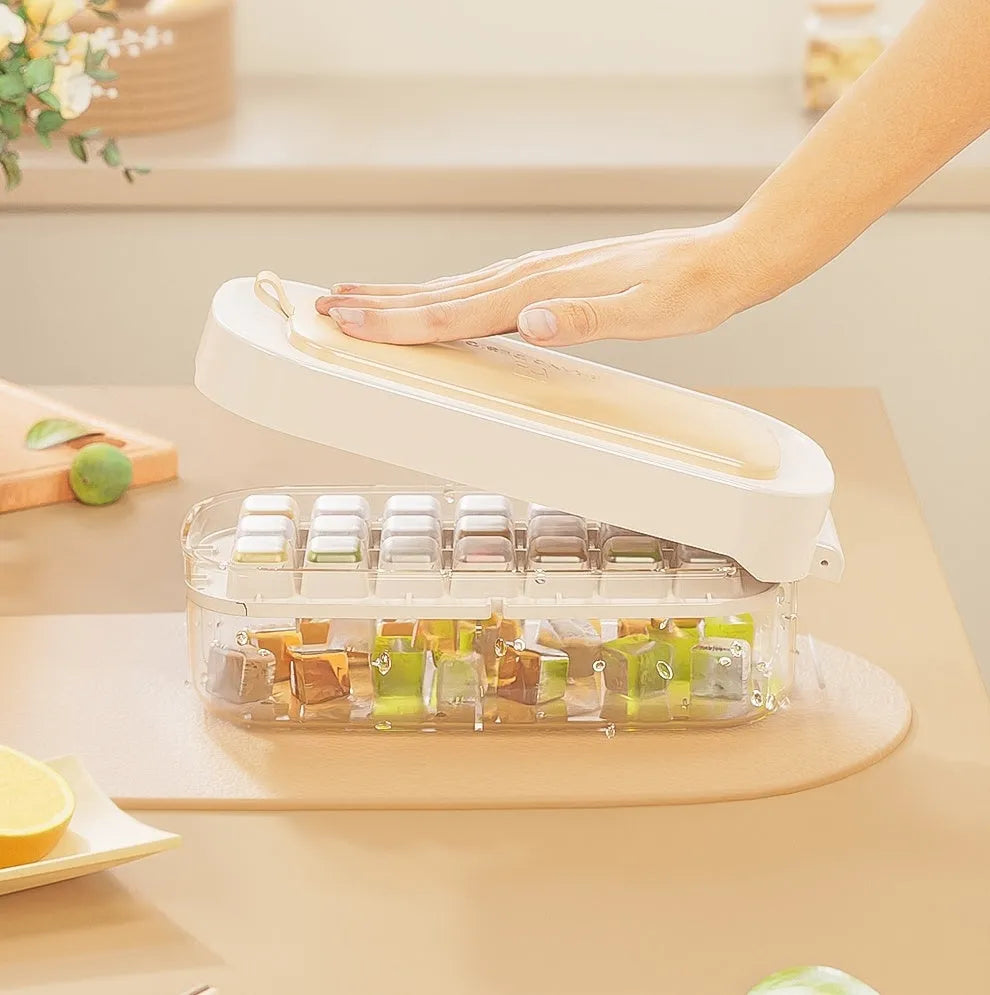 Blue high-capacity ice cube tray with silicone lid and ice scoop stored in its dedicated slot.