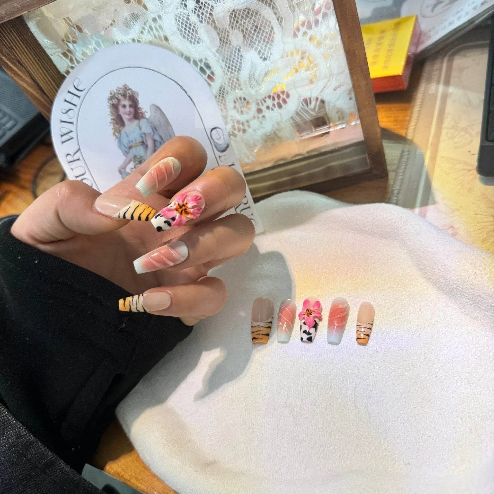 Hand-carved false nails with zebra pattern and lily designs in sizes XS through L