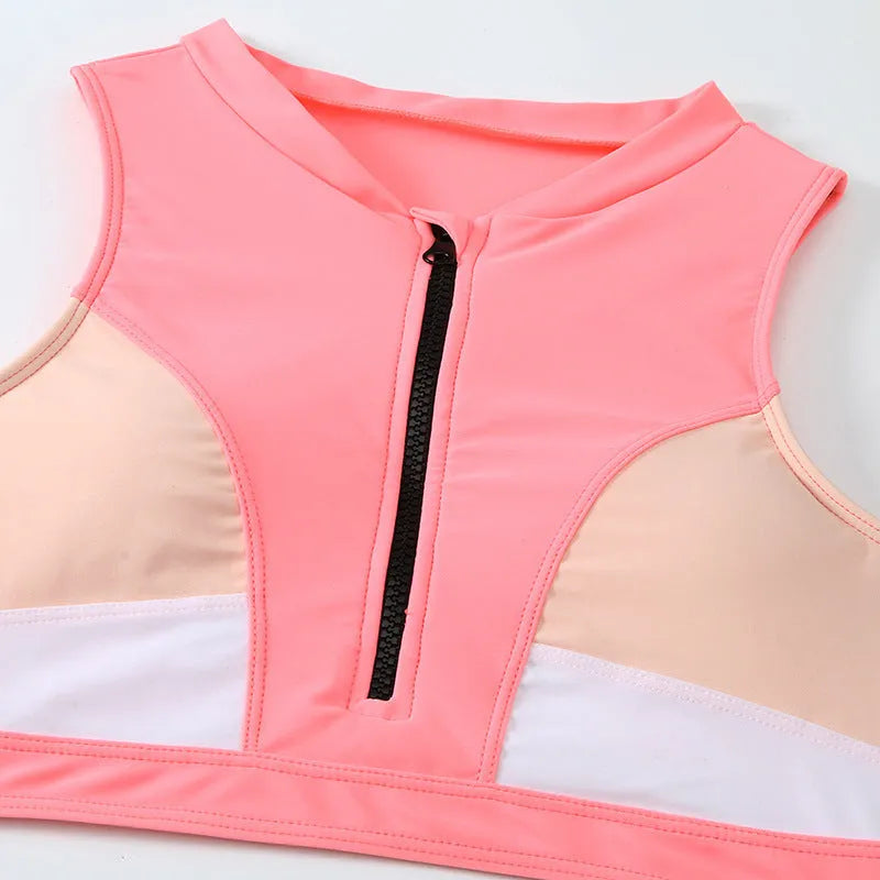 Pink high-waist bikini swimsuit with split shorts on a neutral background.