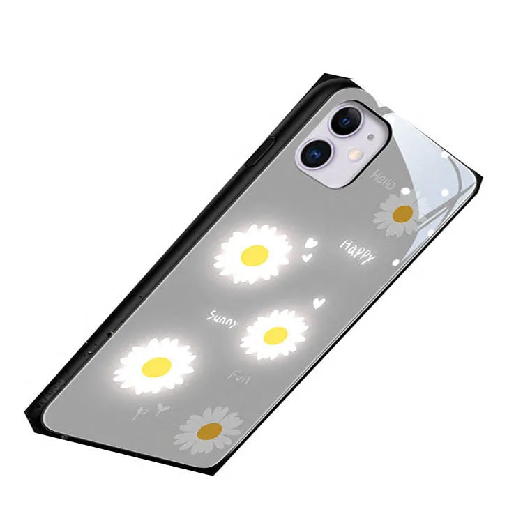White iPhone case with painted purple daisy design and illuminated multi-colour LED lights around the edges.