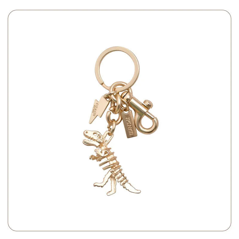 Zinc alloy dinosaur keychain with golden bone dragon pattern on grey background
