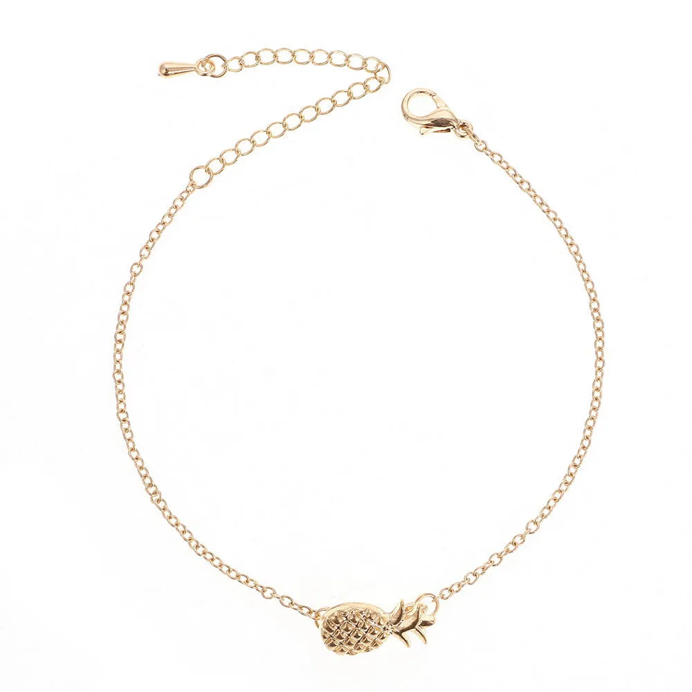 Gold tone alloy bracelet with a detailed pineapple charm on a simple bangle.