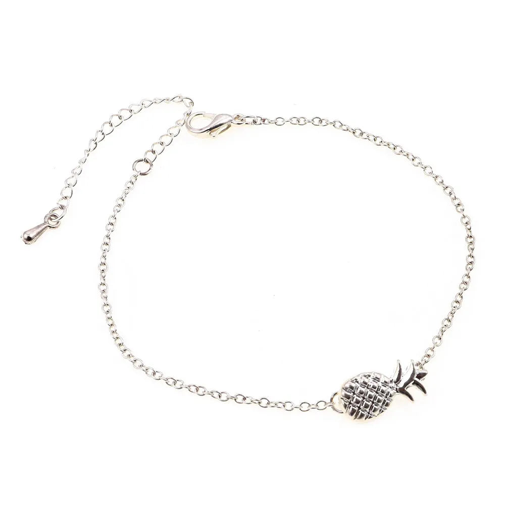 Gold tone alloy bracelet with a detailed pineapple charm on a simple bangle.