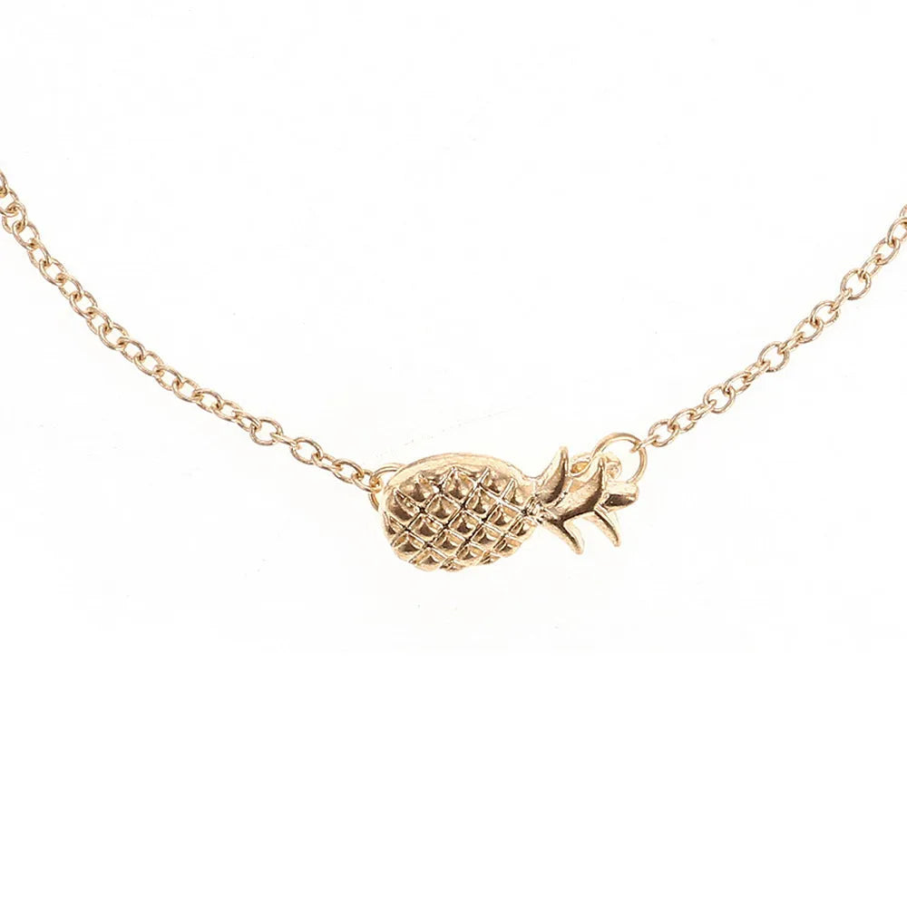 Gold tone alloy bracelet with a detailed pineapple charm on a simple bangle.