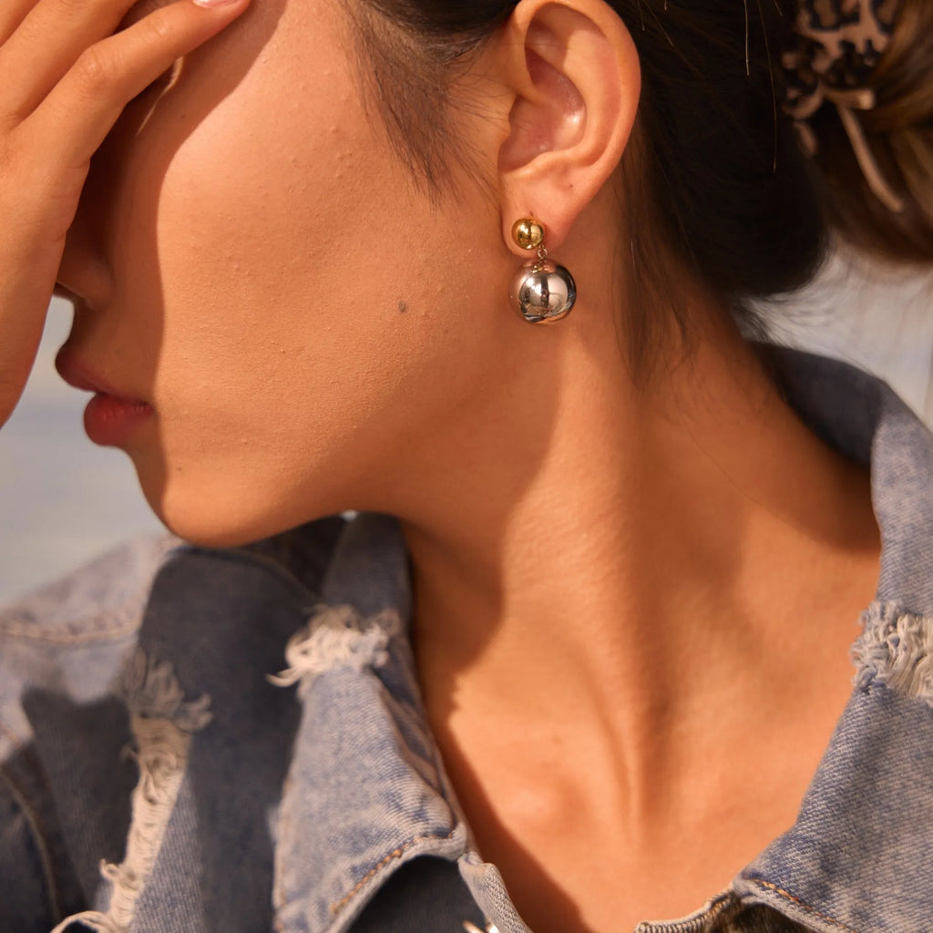 A pair of round bead geometric ear studs with a colour-block electroplated finish on stainless steel.