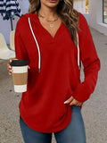 Women's loose fit black hooded V-neck sweatshirt with long sleeves on a hanger.