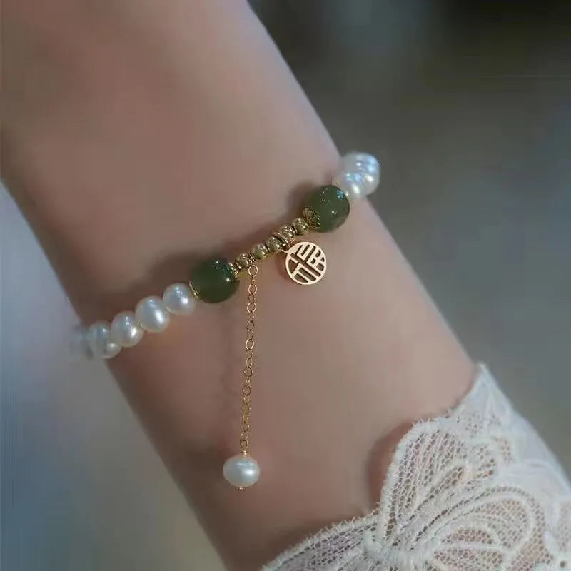 Chinese style glass bracelet with bamboo leaf design on wrist.