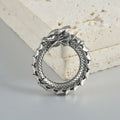 Pair of antique silver dragon-shaped geometric earrings with hollow-out design on a plain background.