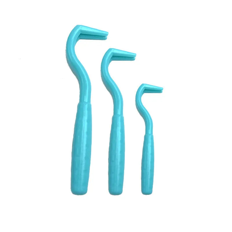 Pack of three coloured plastic tick removal hooks for dogs on a plain background.