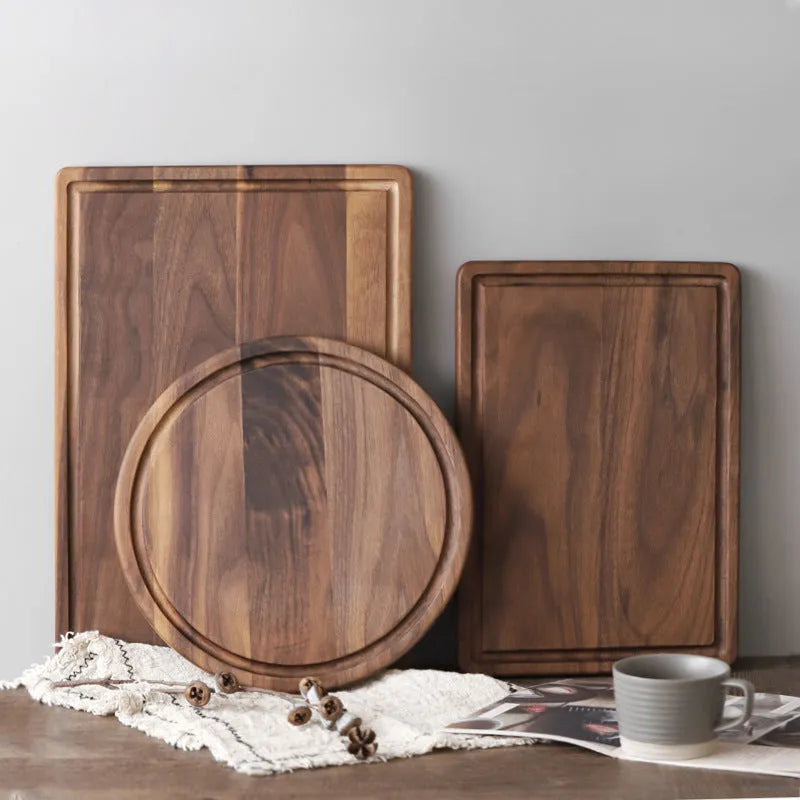 Solid black walnut wood chopping board with juice groove, available in round or rectangular sizes.