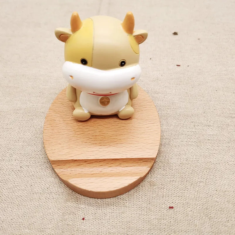 Solid beech wood phone holder with resin puppy decoration and a pound coin in the integrated slot.