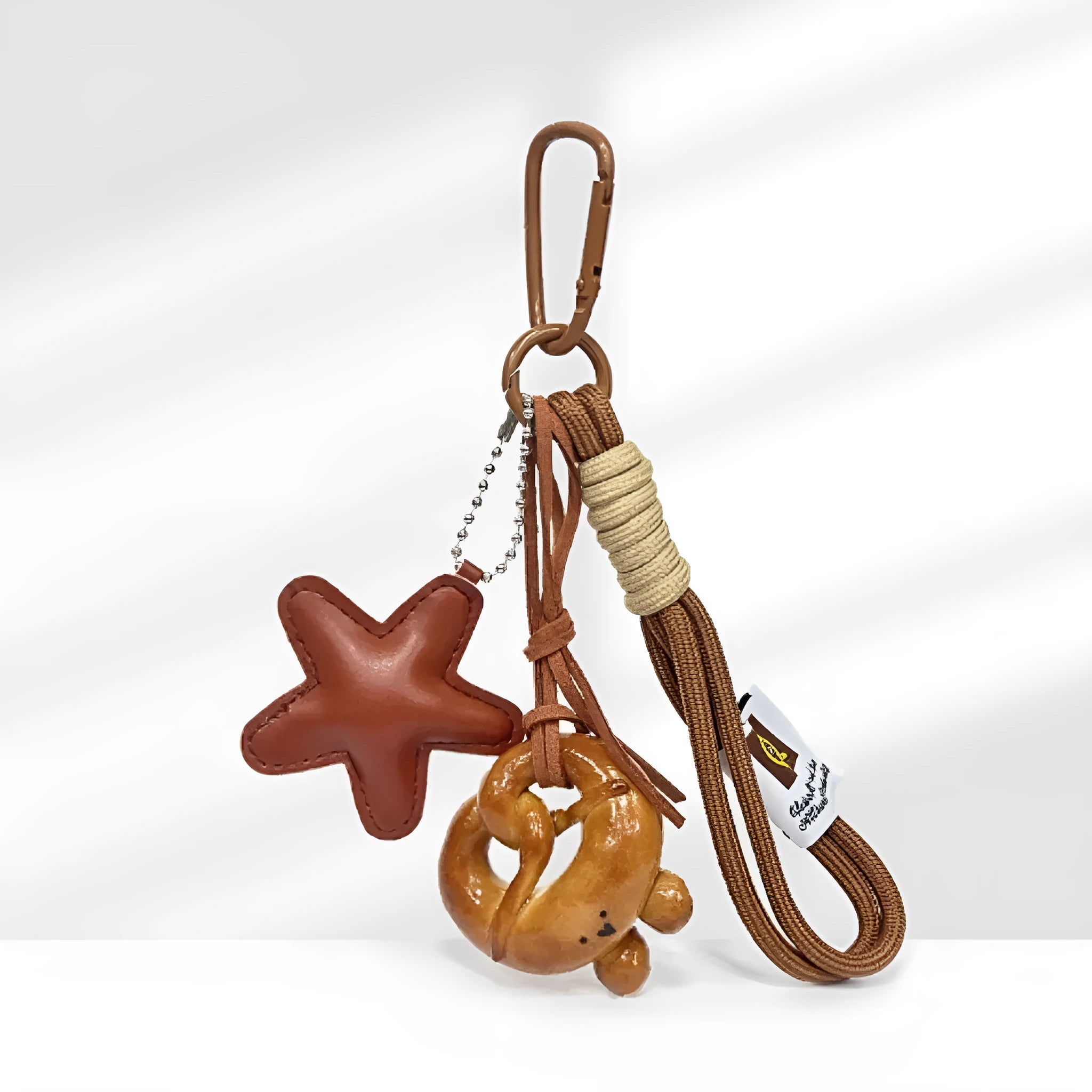Handmade soda bread handbag pendant on a brown strap, showing a cartoon croissant design with a baking varnish finish.