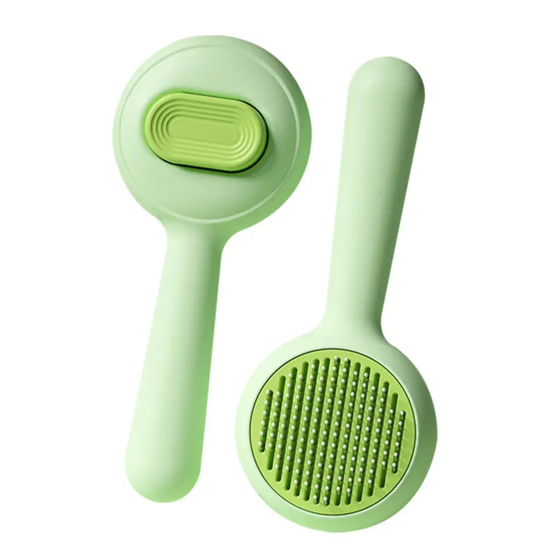 Green cat grooming brush with stainless steel pins and non-slip handle for pet hair removal