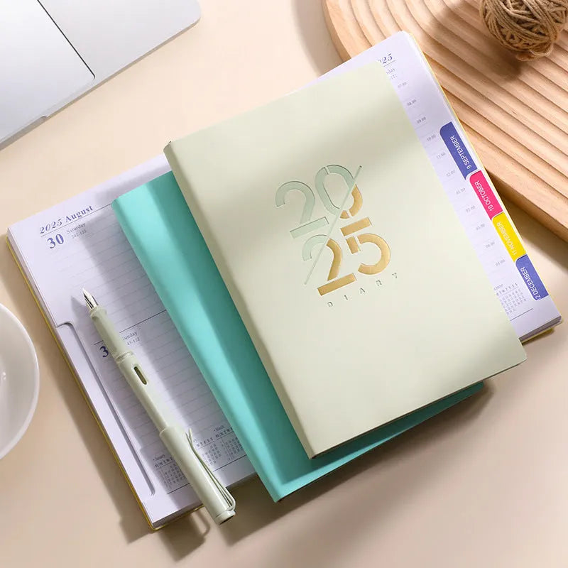 A5 2025 daily planner book with soft faux leather cover in blue colour, showing binding and open pages.