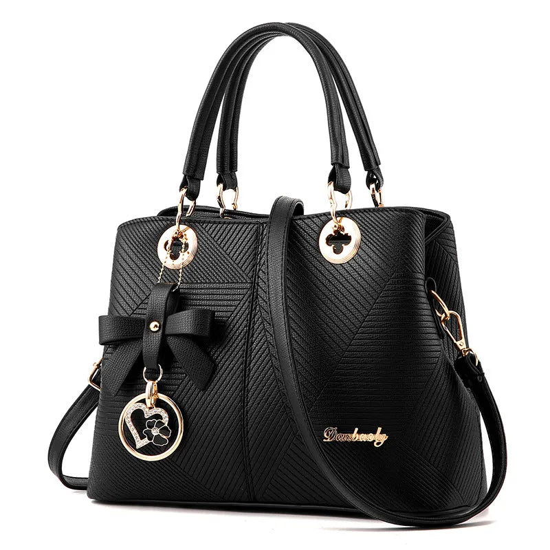 Structured black retro handbag with gold zip and adjustable shoulder strap on a table.