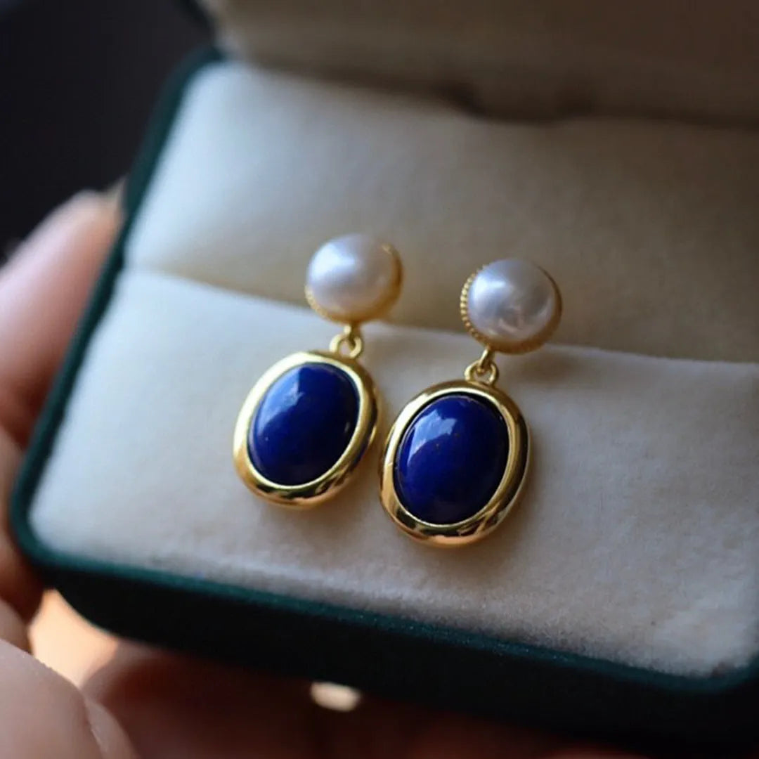 A pair of simple 925 silver earrings featuring a blue lapis lazuli pearl and auspicious pattern detailing.