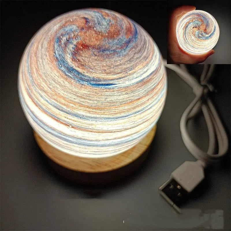 Modern planet-shaped USB night light on its base with dimmable multi-colour glow