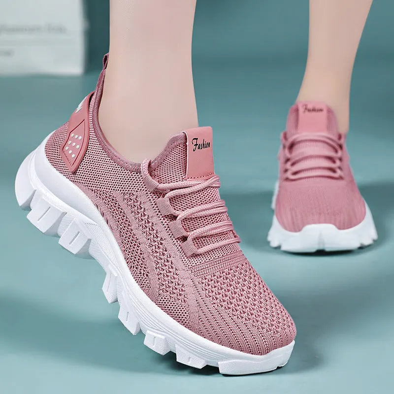 Women's white Flyknit running sneakers with a round toe and flat PVC sole, shown with lace-up front.