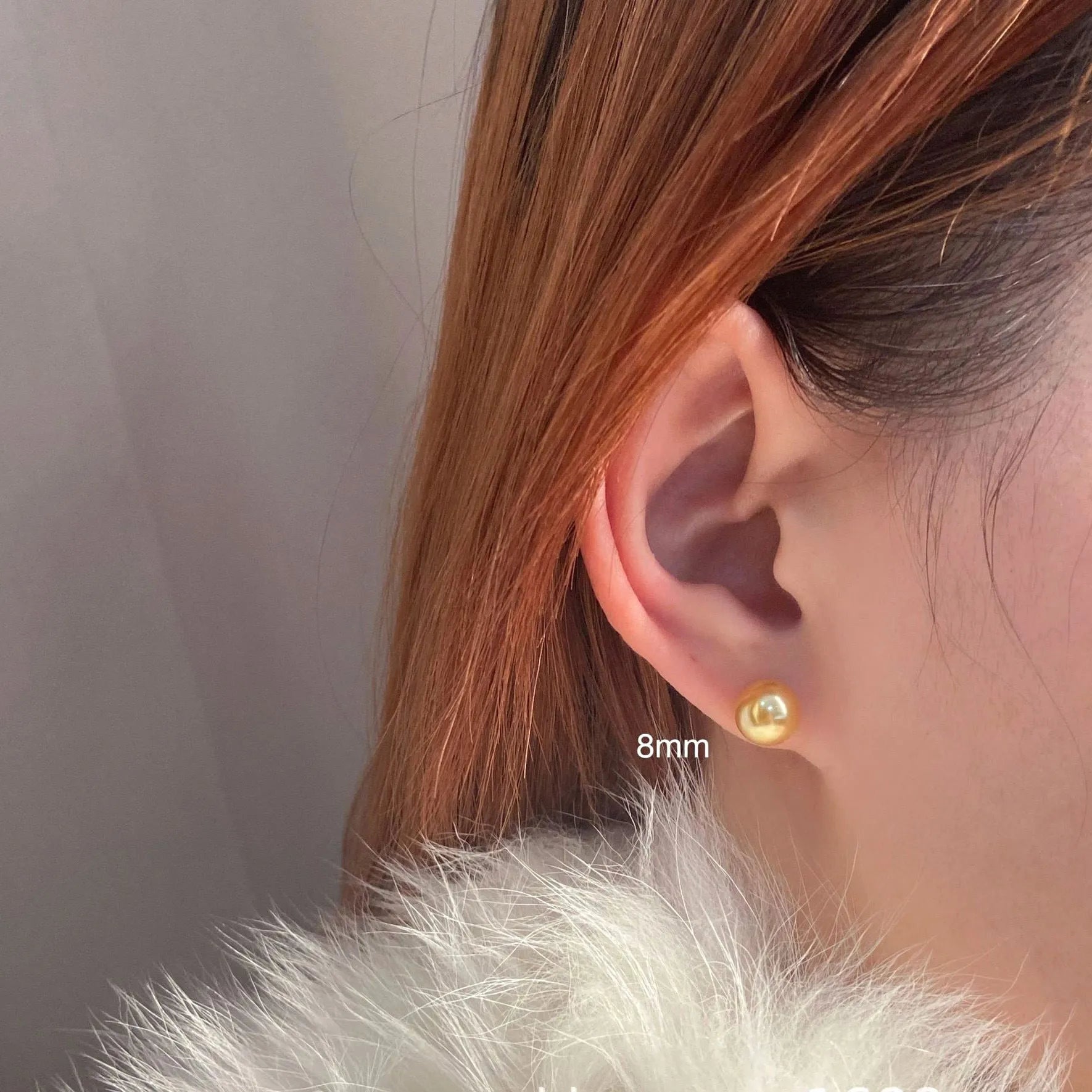 A pair of large pearl stud earrings with a geometric silver setting on a white background.