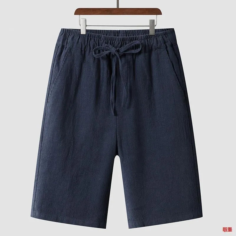 Man wearing beige linen loose-fit cropped shorts on a summer day.