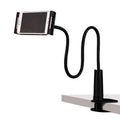 Black aluminium alloy bedside phone handset with a long arm and wide clamp, holding a mobile phone above a bed.