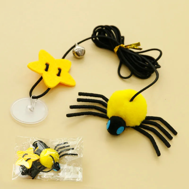 Cat toy with elastic rope hanging over a door, featuring a feather wand, jingle bell, and dangling spider attachment.