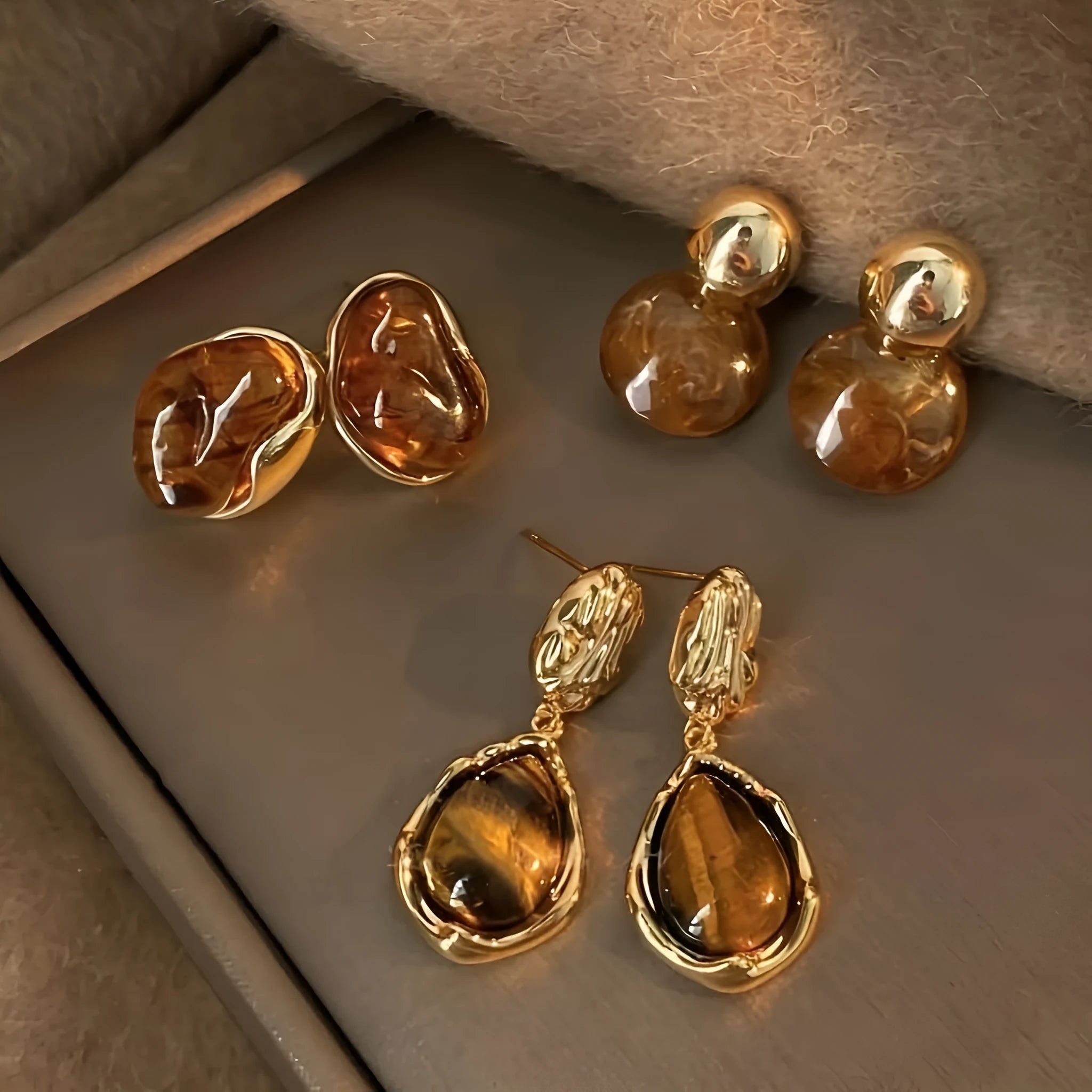 Set of three pairs of geometric alloy holiday ear studs with tassels in different styles.