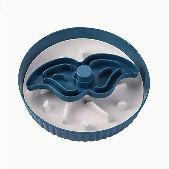 Grey plastic slow feeder pet bowl with windmill pattern and white non-slip silicone base on a kitchen floor.