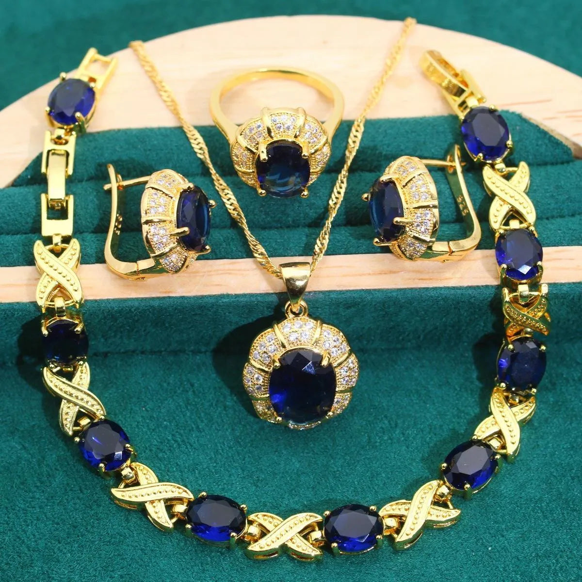 18k gold-plated necklace, bracelet, earrings, and ring set with blue cubic zirconia stones.