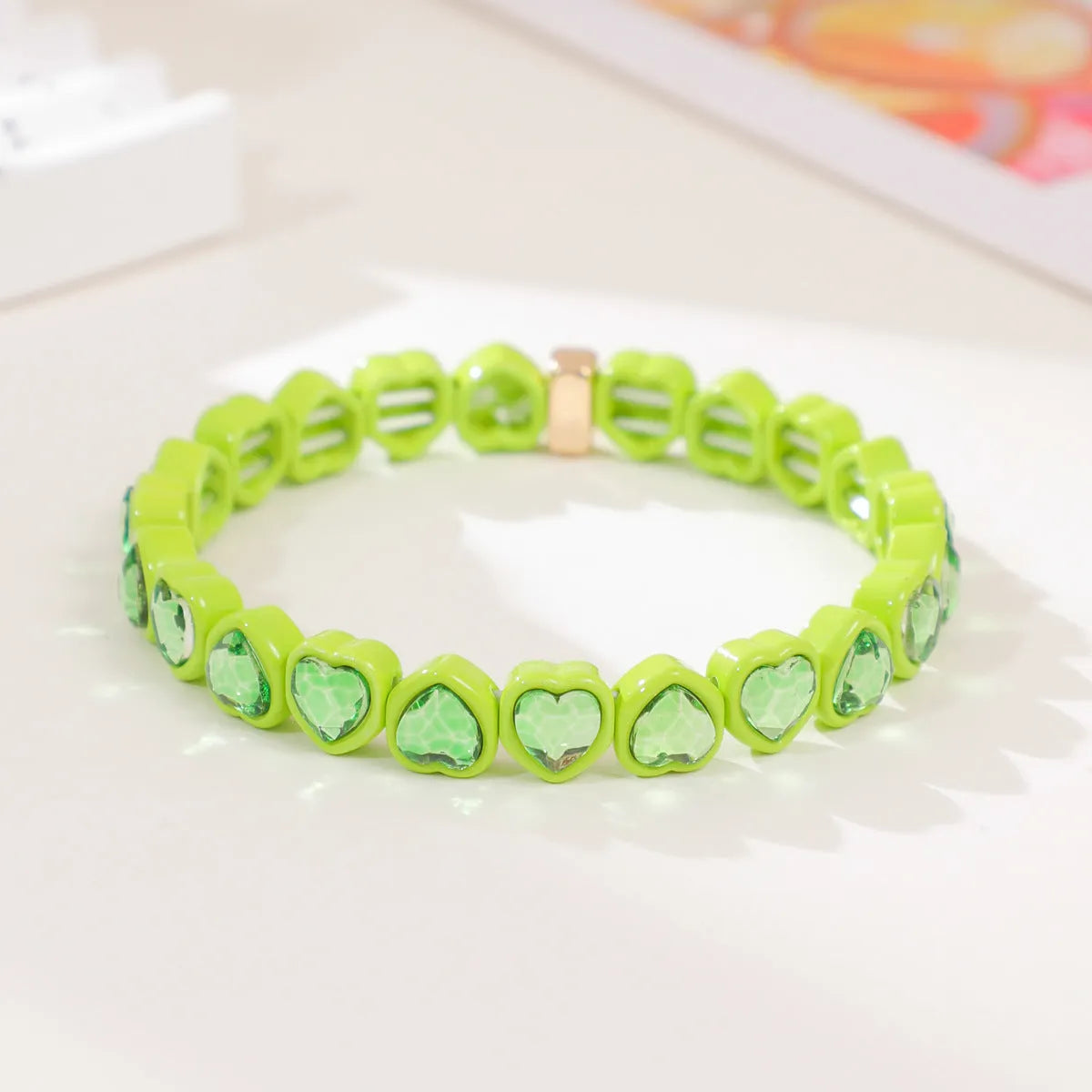 Rainbow enamel heart charm bracelet on alloy base with diamond treatment, stretch band, multicolour design.