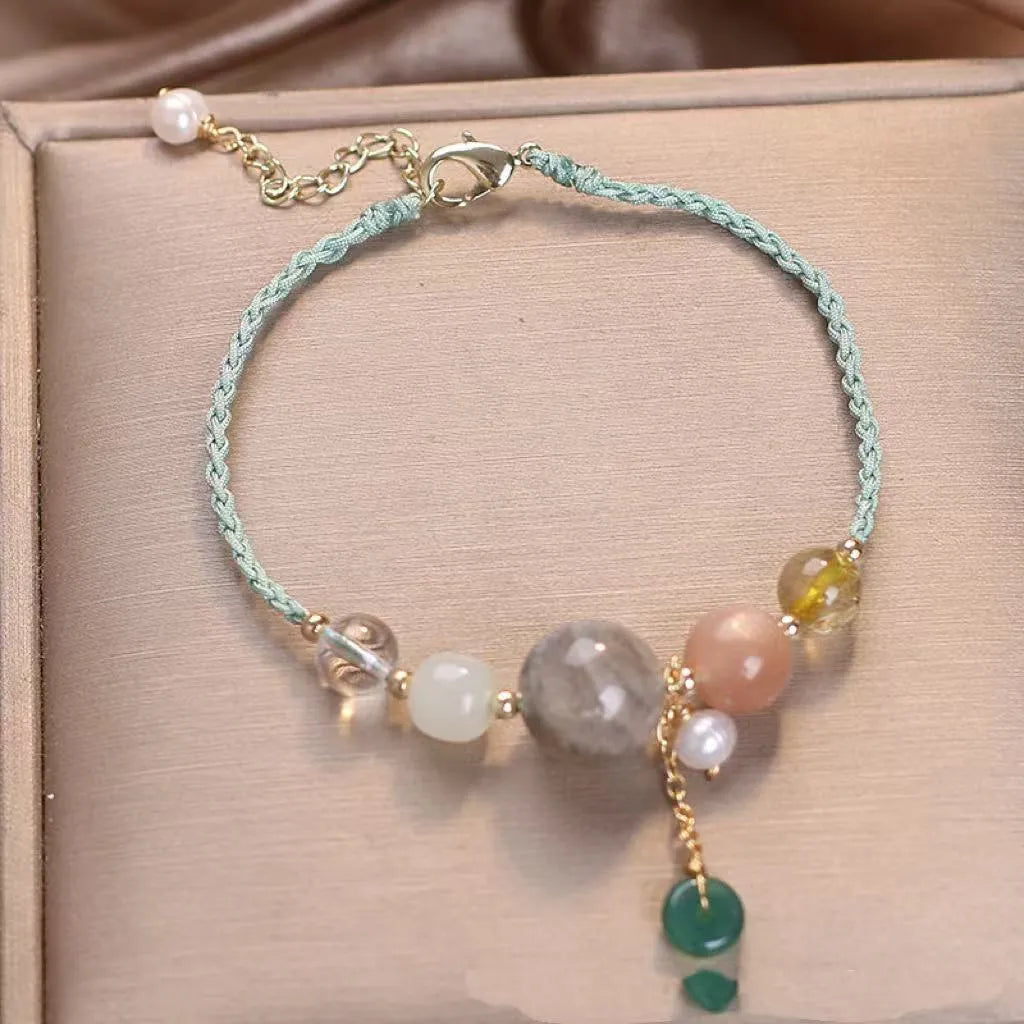 Women's hand-woven bracelet with crystal and sequins on a peace buckle clasp, shown in red, green, and blue colours.