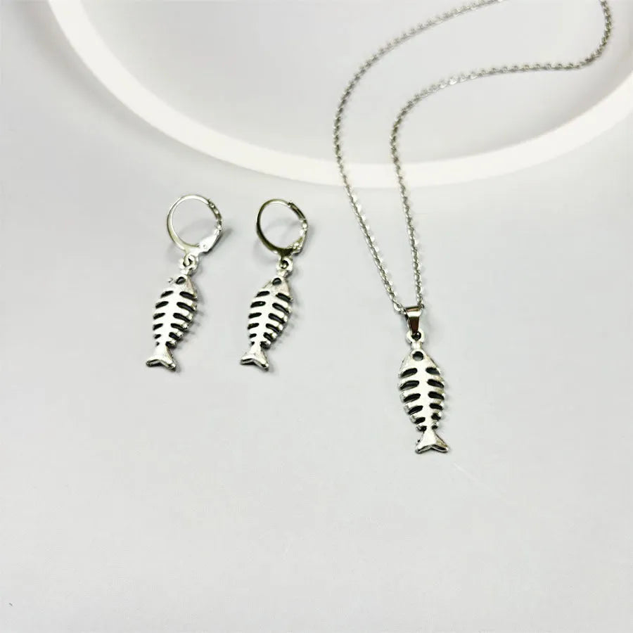 Close-up of retro-style fishbone pendant earrings on an adjustable O-chain.