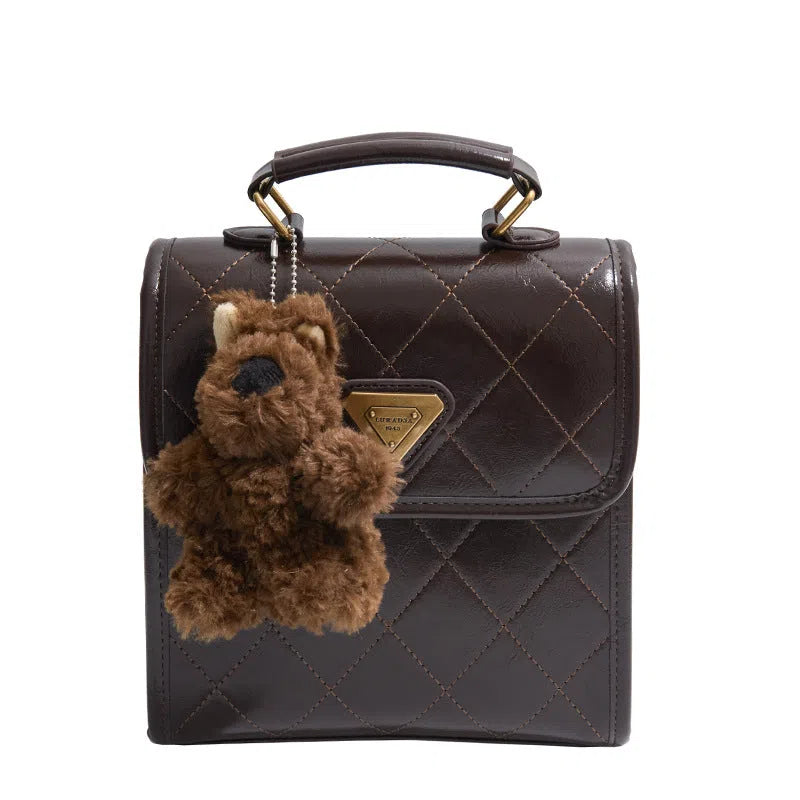 Mini PU backpack in brown with polyester lining, phone pocket, stitching detail, and optional pendant